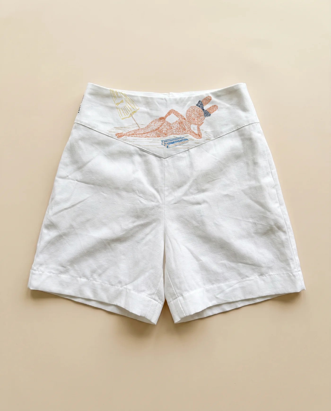 Flat lay of white Not Toys linen shorts